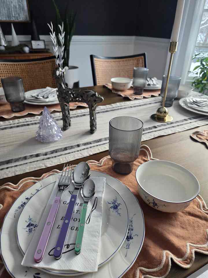 Dining room in wood tone, black, and white featuring a dining table, chairs, and placemats with a cozy atmosphere.