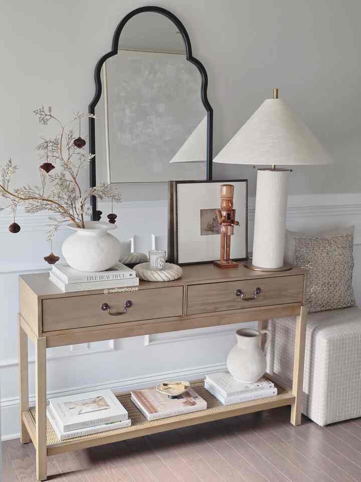 Natural-toned entrance featuring a wooden console table, large mirror, and table lamp creating a cozy atmosphere