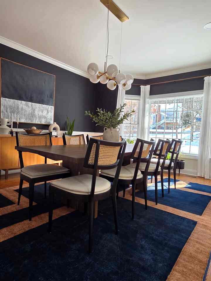 Navy and wood tone dining room featuring a wooden dining table and chairs arranged to create a cozy atmosphere