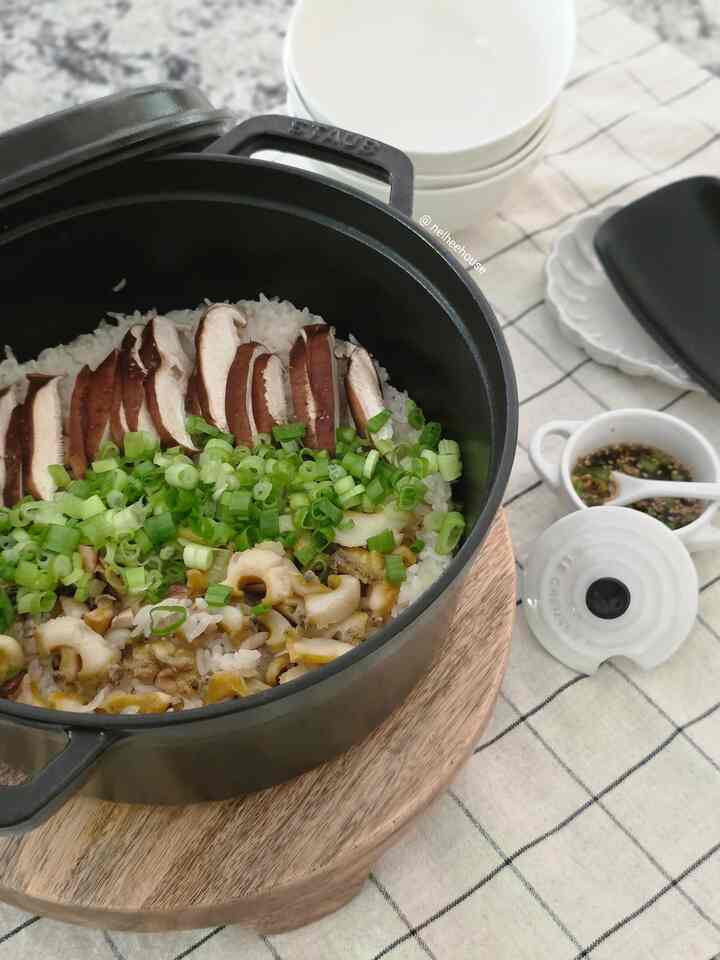 Natural-tone kitchen space featuring a black Staub pot with abalone rice, mushrooms, and green onions