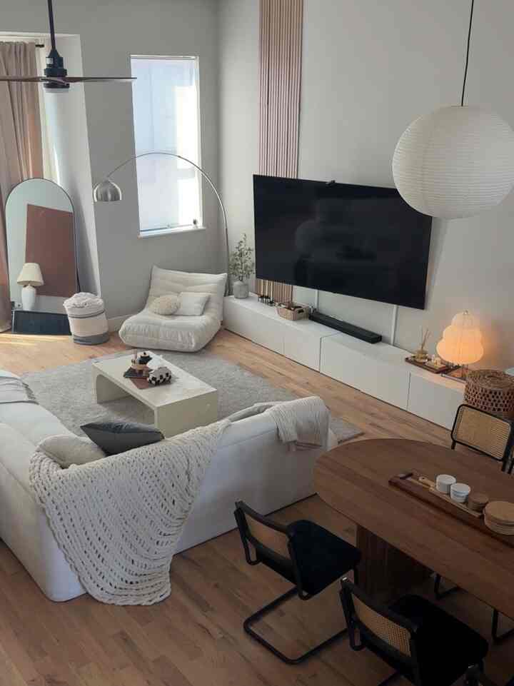 Wood tone and white living room featuring mid-century modern sofa and dining table in a minimal and natural space