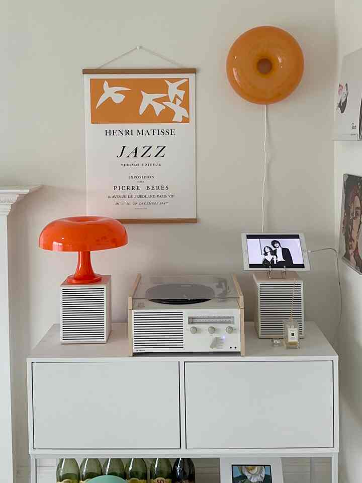 Orange-accented lighting in white living bar space featuring vintage audio setup with cozy atmosphere for music enjoyment