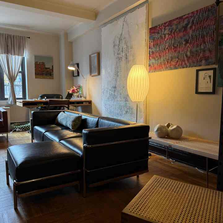 Living room with wood tones and black elements, arranged with modern sofa and desk creating a cozy atmosphere
