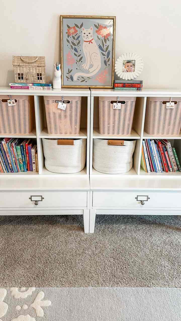 White and beige toned kids' room featuring organized bookshelf and baskets with a simple Nordic style