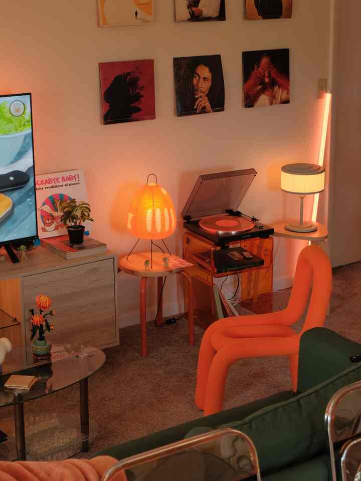 A warm orange and wood tone living room music corner featuring vintage LPs and a turntable creating a cozy atmosphere