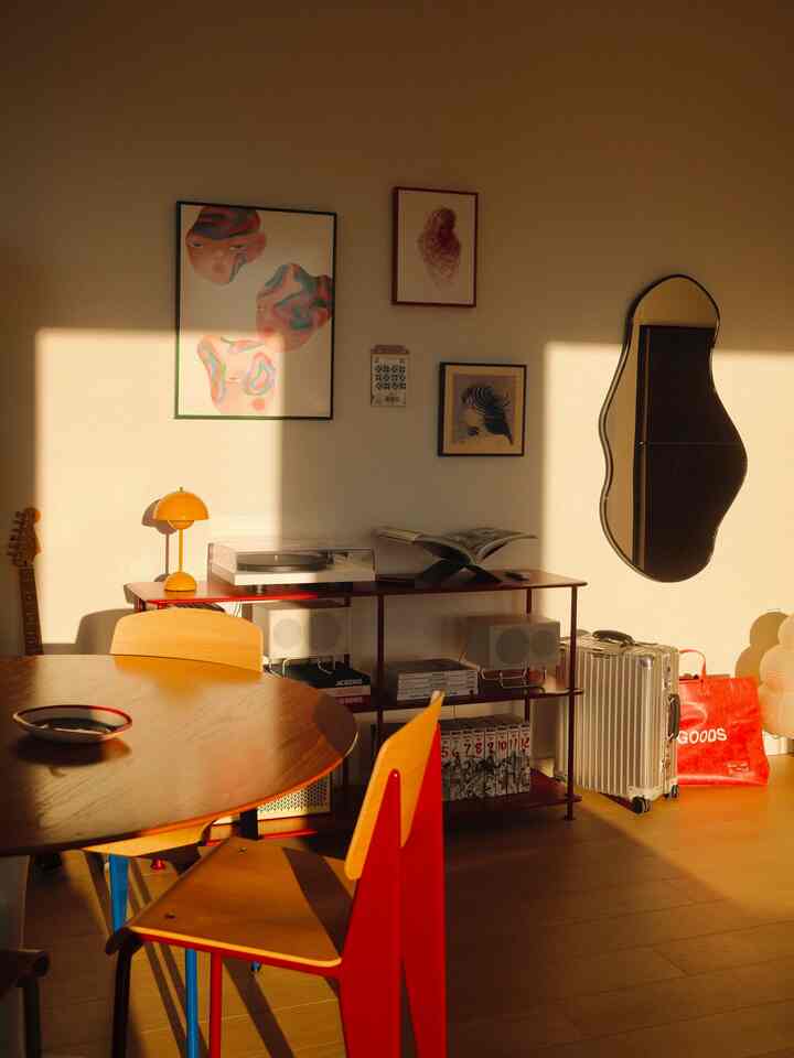 Warm brown wood tone dining room featuring round table and record player in a modern setting