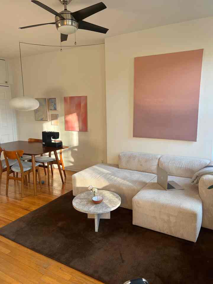 Mid-century modern living room with warm wood tones and cream sofa, bathed in natural evening light