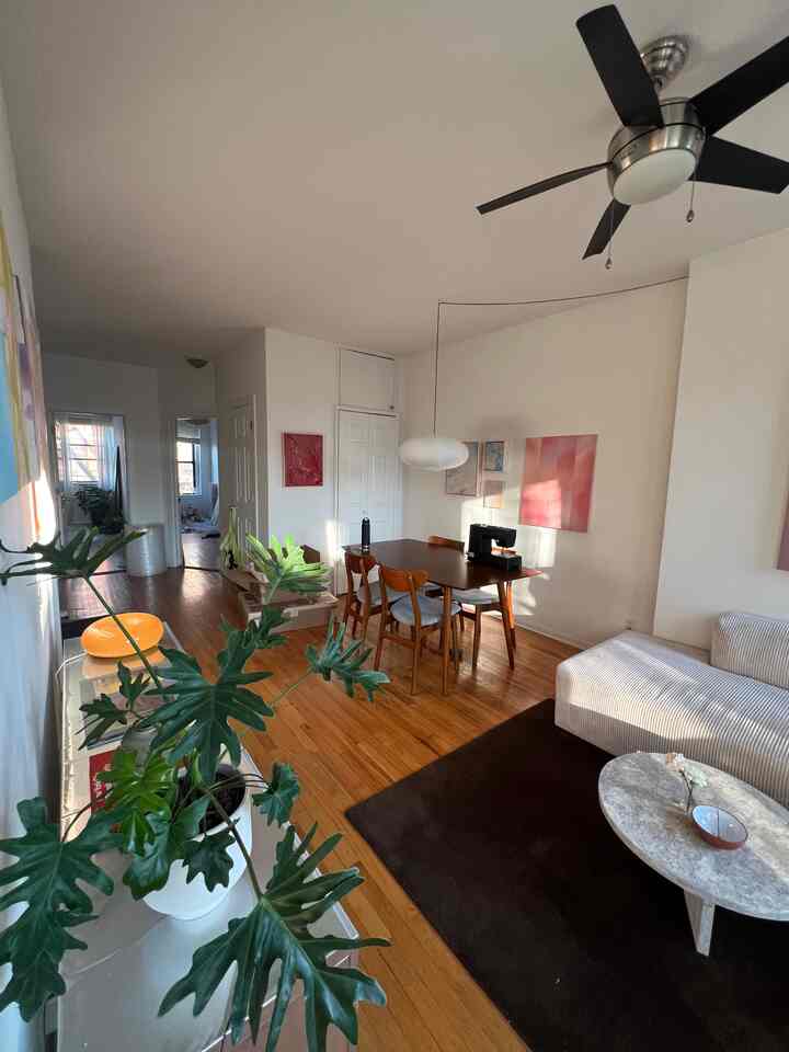 Wood tone and white mid-century modern living and dining room featuring sectional sofa and dining table with warm, clean atmosphere