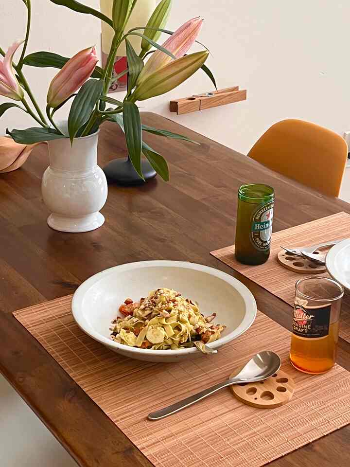 Natural-toned dining room featuring a wood dining table, vase with flowers, and tableware in a cozy setting