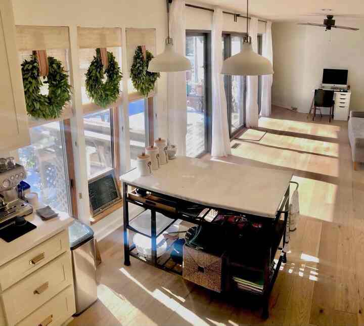 Bright, modern kitchen and dining room with natural colors and wood tones featuring pendant lights