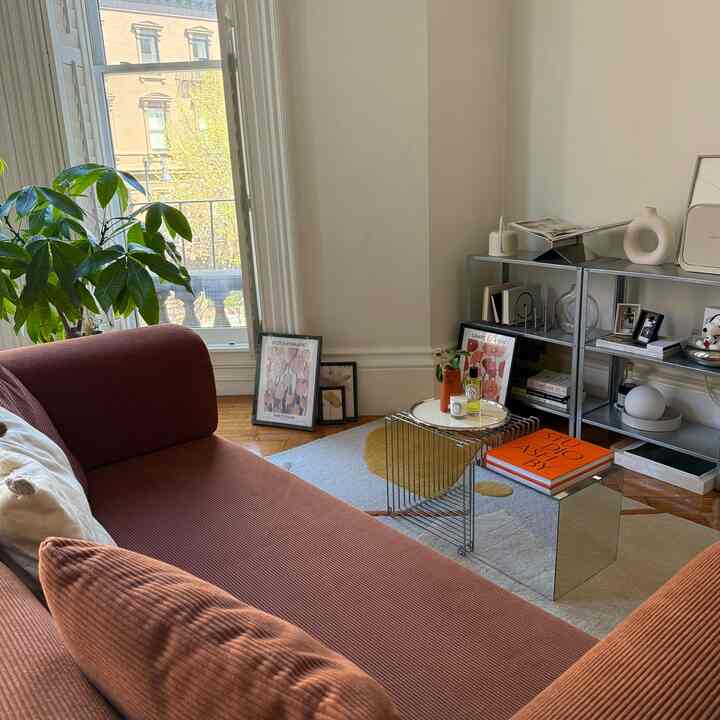 Natural color living room with brown sofa and chrome side tables combined as coffee table