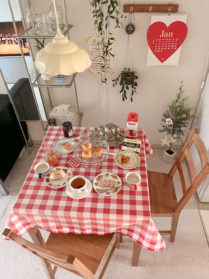 Natural wood dining room with red and white checkered tablecloth, cozy cafe style featuring vintage teacups and teapot