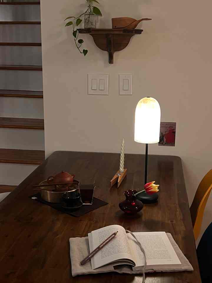 Warm natural-toned dining room featuring vintage shelf and table lamp with cozy atmosphere