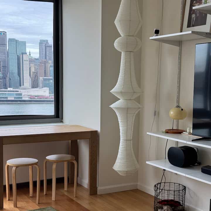 White walls and wood-tone furniture in a Japandi-style two-person living room with simple, cozy atmosphere