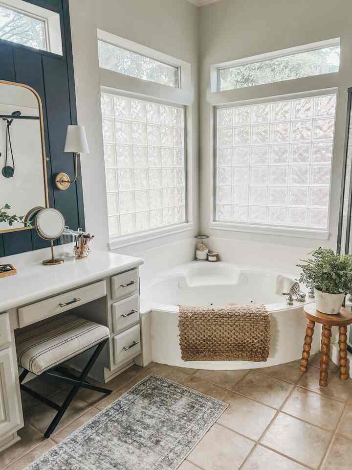 White and beige toned bathroom featuring a bathtub, vanity, and natural décor elements for a cozy atmosphere