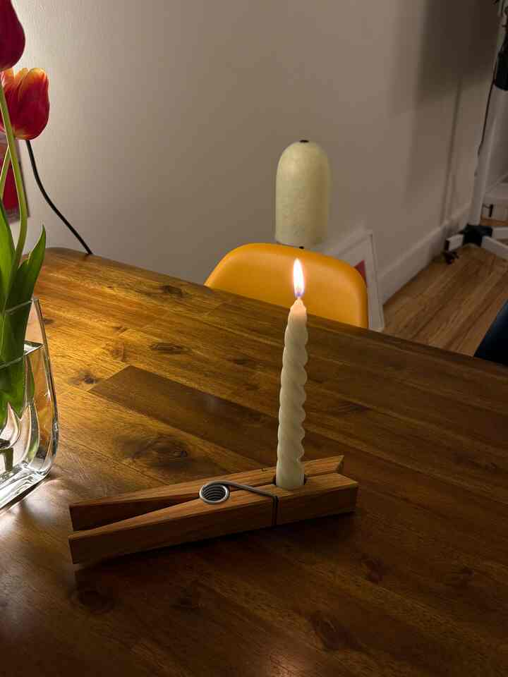 Warm brown toned dining room featuring a wooden dining table with a lit spiral candle creating a cozy atmosphere