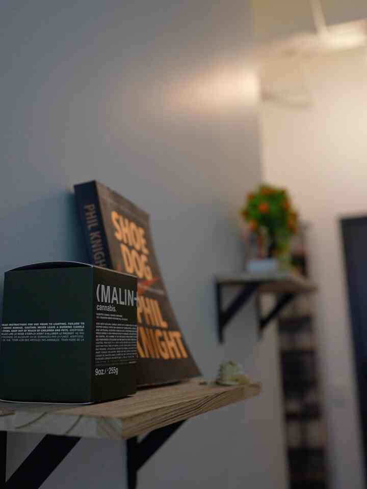 A cozy minimal interior space with natural wood tone floating shelves mounted on white walls in a small room