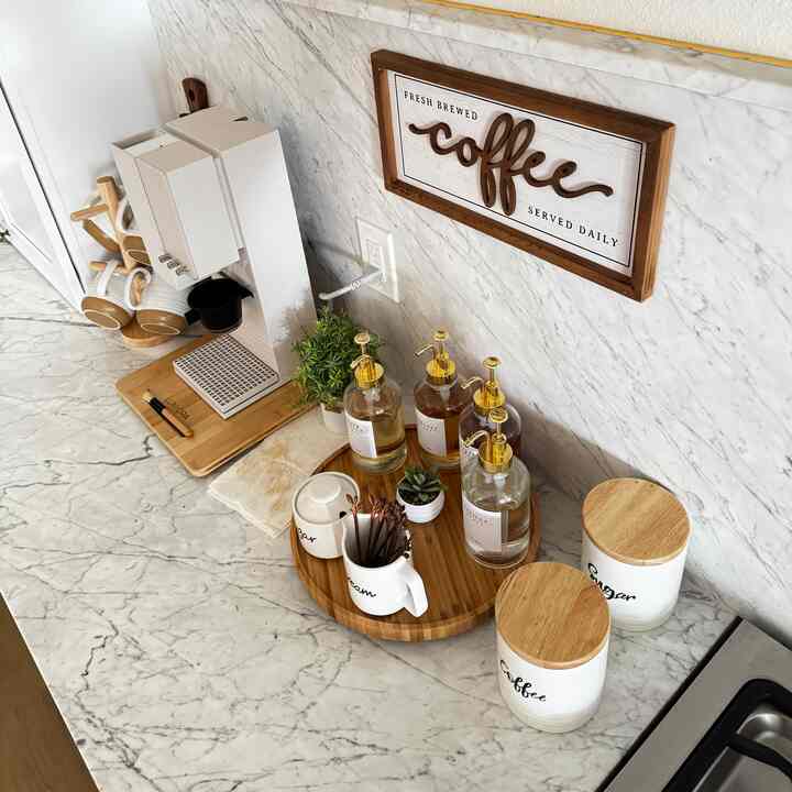 Minimal kitchen with wood tones and white accents, featuring a coffee machine and coffee accessories arranged neatly in a home cafe setup
