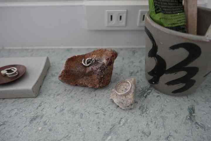 グレーと翡翠色を基調とした洗面台の天板にアクセサリーが配されたナチュラルなバスルームインテリア。