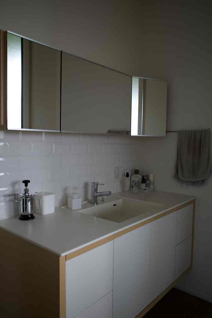 白とナチュラルカラーのミニマルなバスルーム洗面スペース、シンプルで清潔感あるインテリア