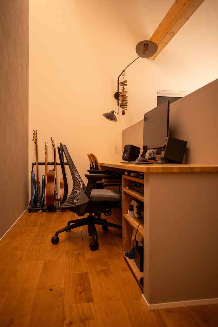 暖かみのある木目調とベージュの色調が調和したコンパクトなホームオフィス、机とオフィスチェアが配された集中できる環境