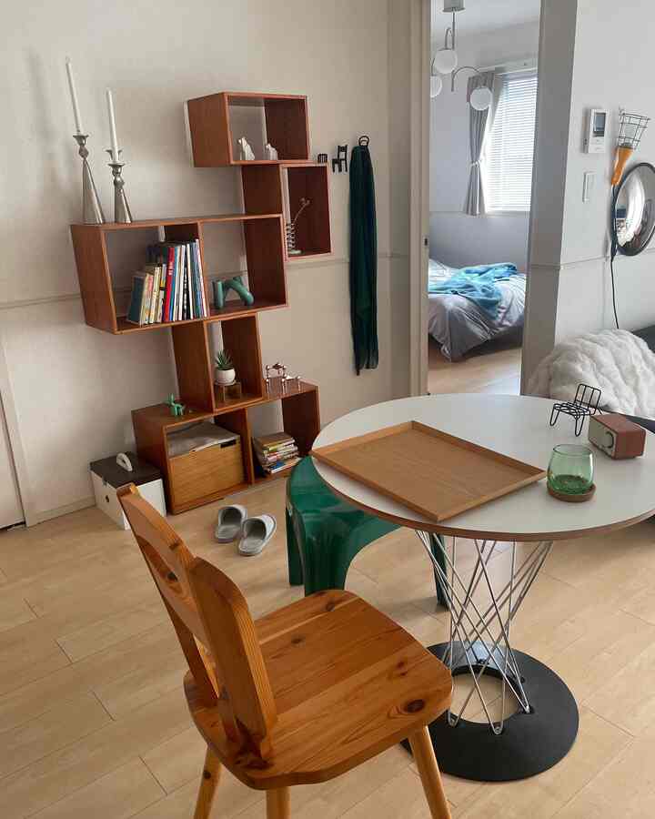 ホワイトと木目調のコンパクトなダイニング、ナチュラルな木製チェアと独特の木製ラックが配置されたナチュラルモダンな空間