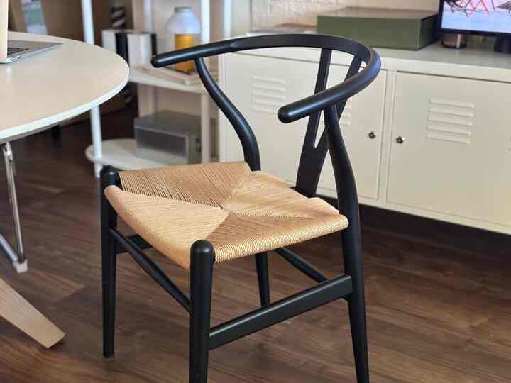 ナチュラルカラーのラタン座面と黒いフレームのダイニングチェアが配置されたモダンなダイニング空間