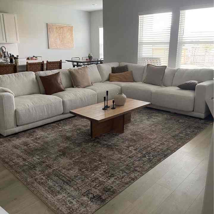 Natural and wood tone living room featuring a large beige sofa and wood coffee table, creating a cozy and comfortable atmosphere