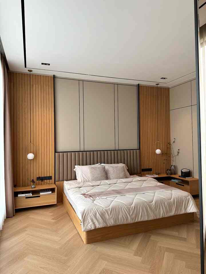 JEAN HOUSE second master bedroom.

Kamar tidur ini terlihat sangat nyaman dengan desain yang minimalis dan modern. Dinding kayu vertikal di samping tempat tidur memberikan suasana hangat dan alami, sementara panel dinding di belakang tempat tidur menciptakan kesan elegan. Tempat tidur dilengkapi dengan headboard empuk yang memberikan kenyamanan ekstra untuk bersandar.

Lantai kayu dengan pola herringbone menambah kesan mewah dan menenangkan. Lampu gantung di kedua sisi tempat tidur memberikan pencahayaan lembut yang cocok untuk suasana malam hari. Meja samping tempat tidur yang simpel memberikan ruang untuk menyimpan barang-barang penting dengan mudah.

Secara keseluruhan, ruangan ini menciptakan suasana tenang dan damai, ideal untuk bersantai dan mendapatkan tidur berkualitas. #bedroomstyling #inspirasikamar #lampukamar #lantaikamar #spreiranjang #bantal #bedcover