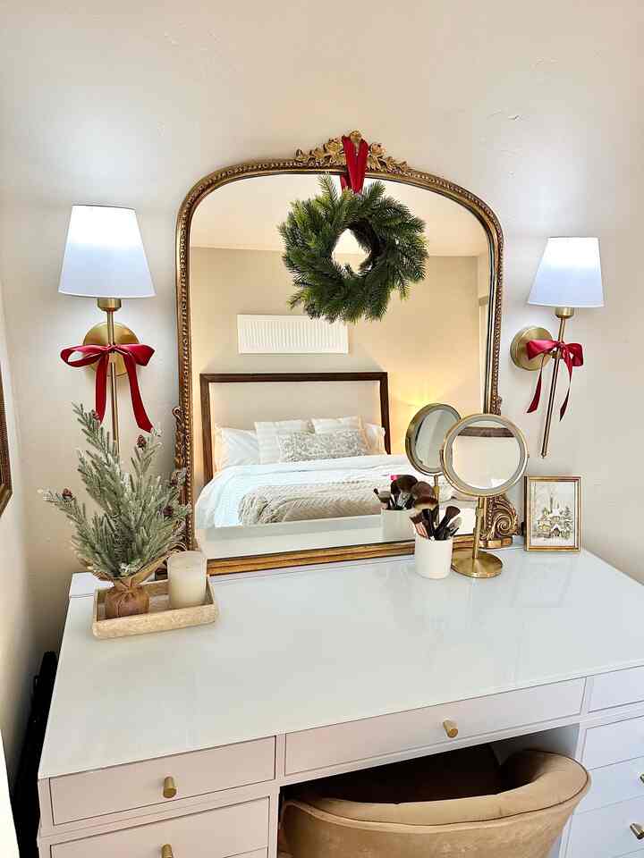 Decorated my makeup vanity for the Holidays! It had been fun getting ready here every day. #makeupvanity #christmasdecor #miniwreath #wreath #christmas #bows #vanitymirror 