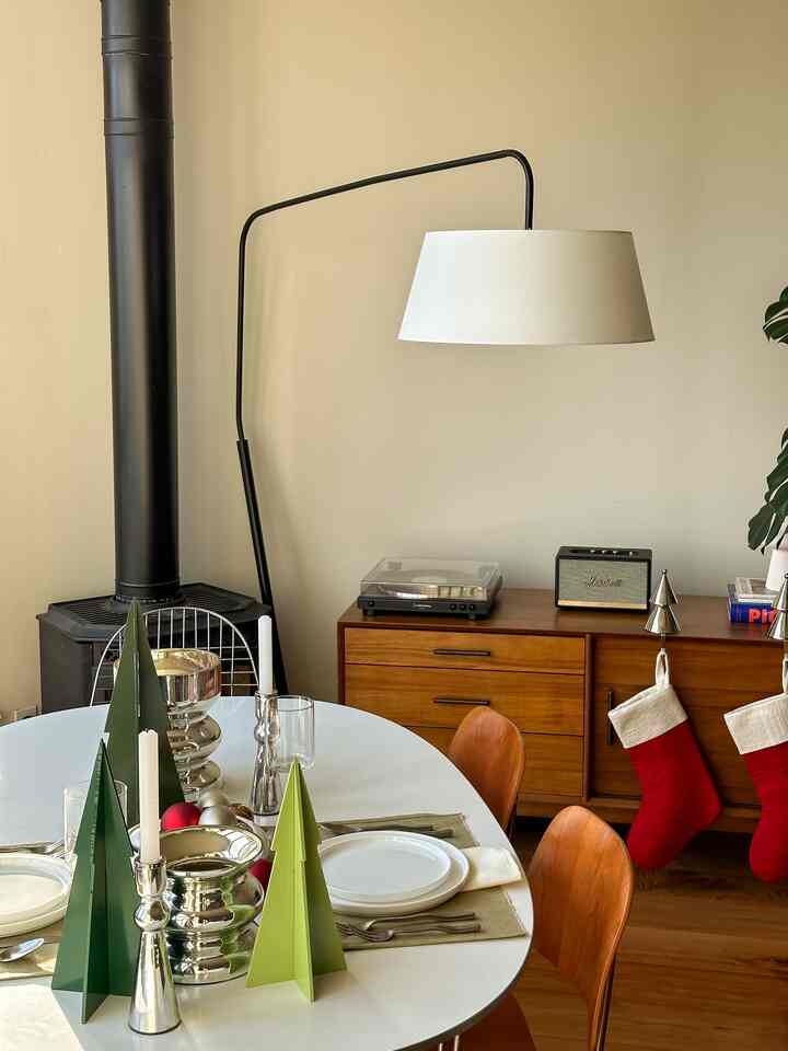 Wood-toned and green-red accented 4-person dining room featuring modern dining table with holiday decorations