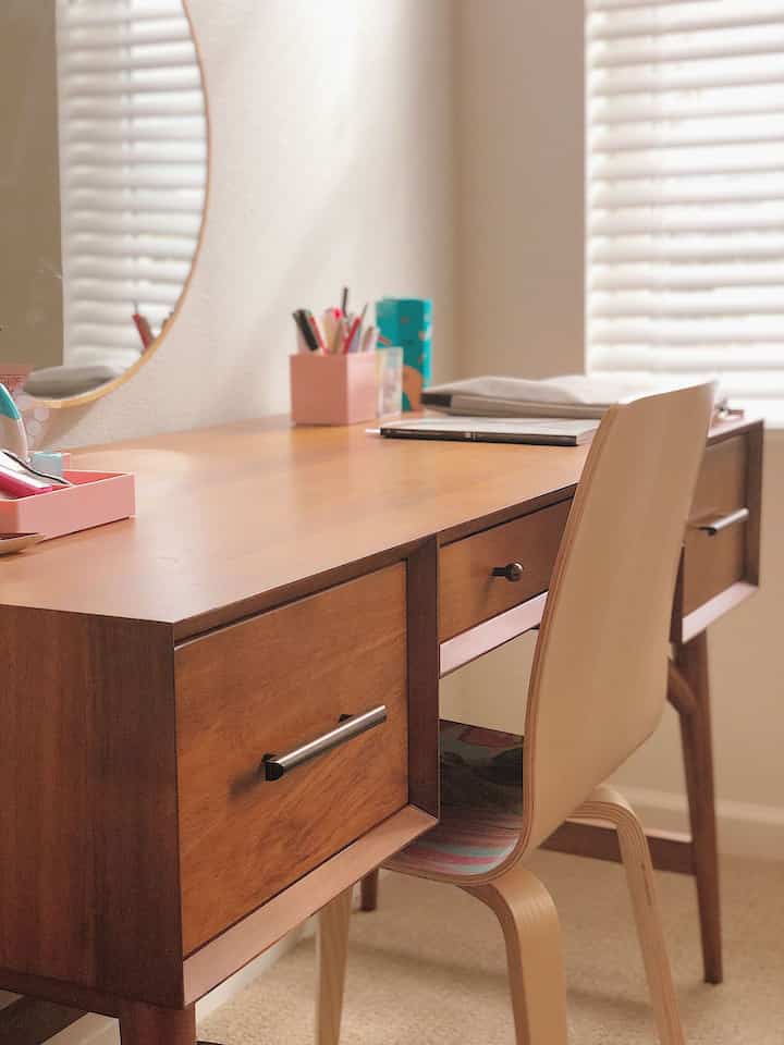 Natural-toned home office space featuring a Mid-Century Modern desk with a round mirror, creating a cozy interior