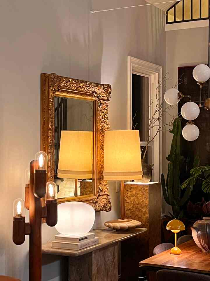 A gold-toned living room space featuring retro lamps and wood-toned furniture creating a warm ambiance