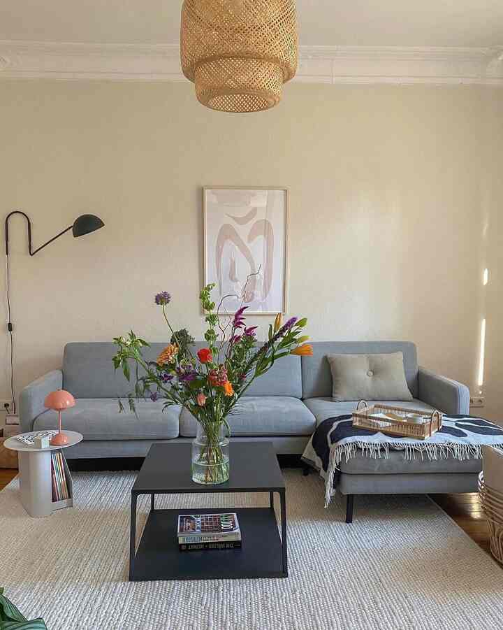 Light gray and natural toned living room featuring sectional sofa and coffee table in a simple modern setting