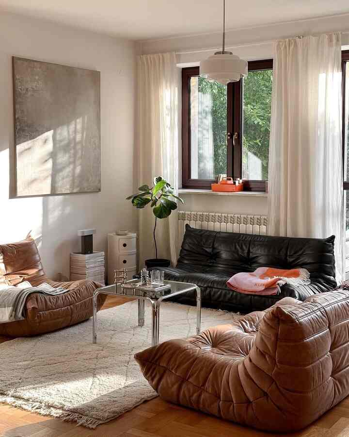 Natural-toned living room featuring brown and black leather sofas in a mid-century modern style