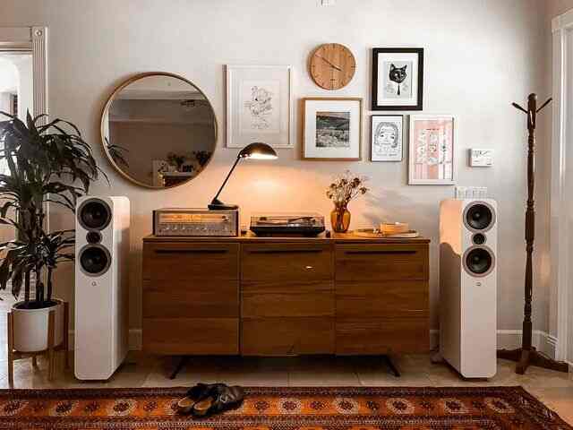 Bright wood-tone living room with large central sideboard and gold table lamp arranged in mid-century modern style interior