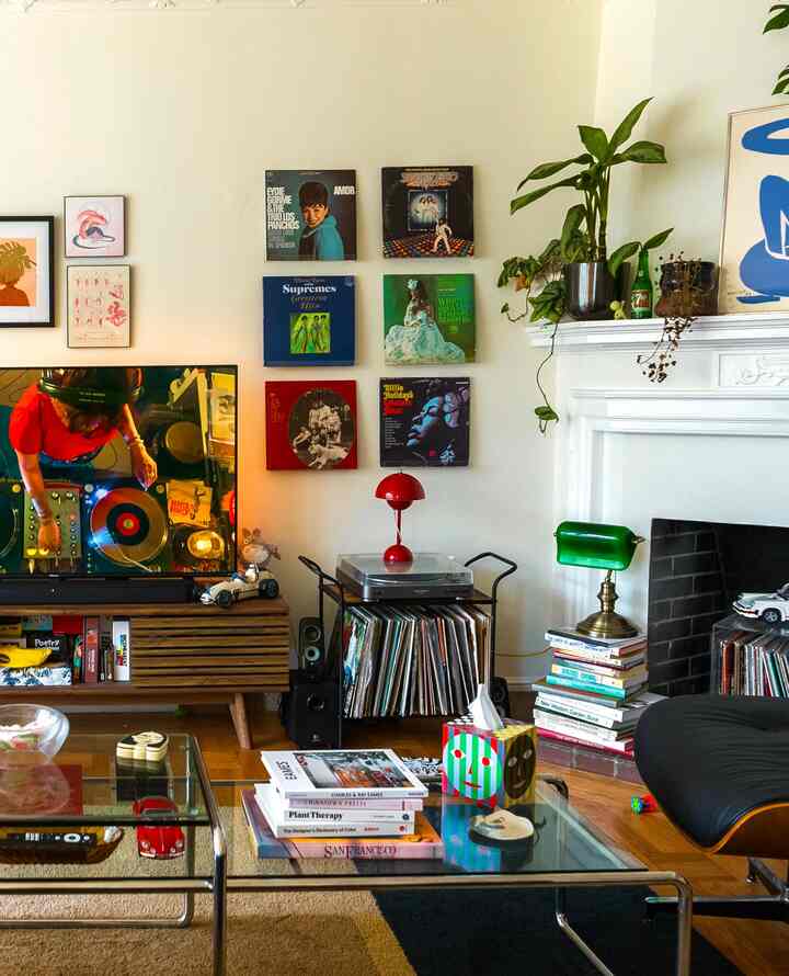 Beige and brown toned living room featuring vinyl LP display on wall, a record player, and vintage furniture creating cozy atmosphere