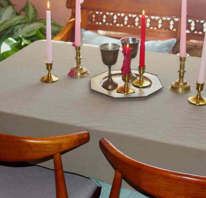 Beige-toned dining room featuring wooden dining chairs and gold candlestick holders, creating a warm atmosphere