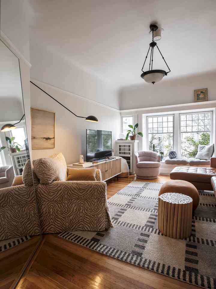 Beige and wood-toned living room featuring media console and assorted sofas in a modern setting