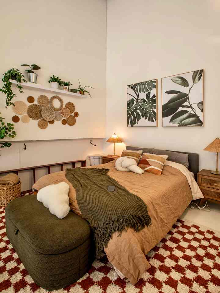 Beige and brown toned loft bedroom featuring botanical wall art and rattan wall lamps, creating a natural and cozy atmosphere