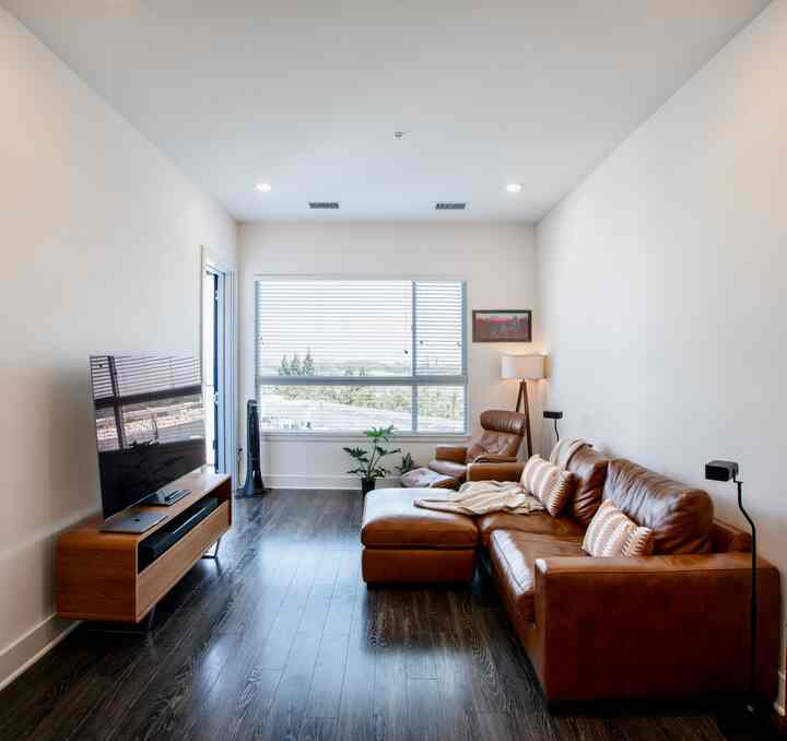 Bright warm living room featuring brown leather sofa and recliner furniture