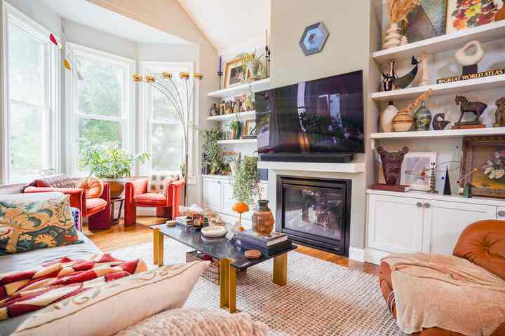 Bright living room with wood tones and red accents, featuring Mid-Century Modern and Vintage sofas and armchairs in a cozy arrangement