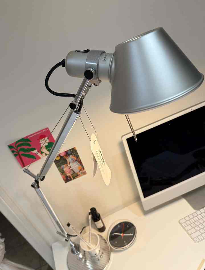 White and silver toned home office featuring iMacs and an Artemide Tolomeo Classic lamp on a clean desk workspace