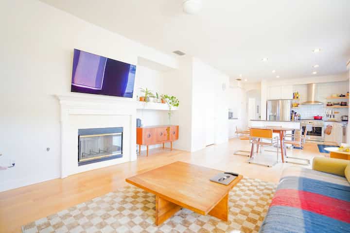 White-walled, wood-toned living and dining room for 4, featuring mid-century modern furniture and a simple, natural atmosphere