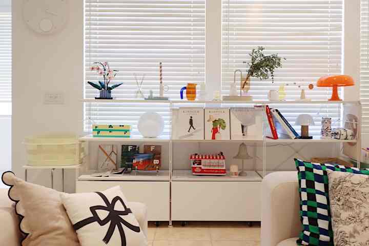 Bright white-toned living room featuring mid-century modern sofa and table lamps creating a cozy interior