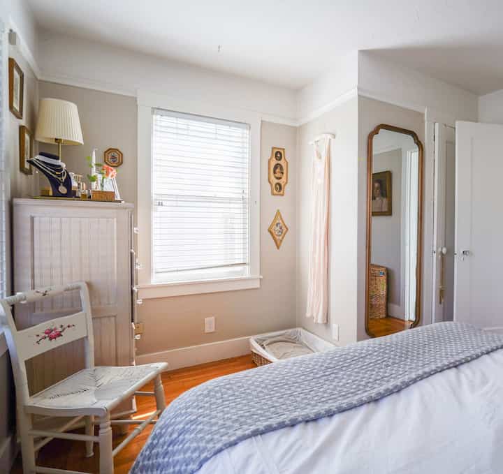 Soft white and brown toned bedroom featuring cozy cottage-style furniture and natural light blending harmoniously