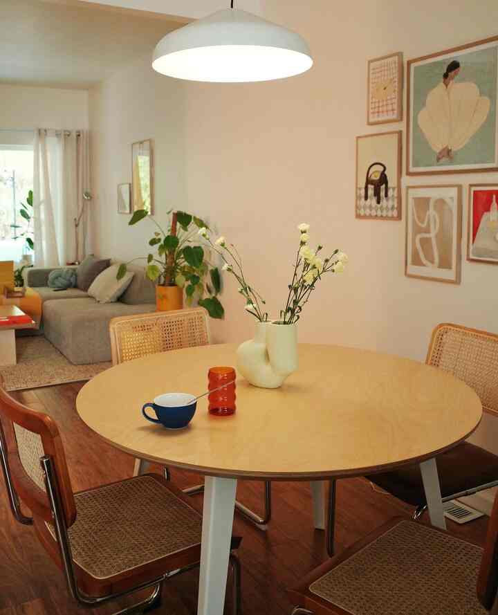 Beige and wood tone living and dining room with round dining table and sofa creating a cozy natural atmosphere