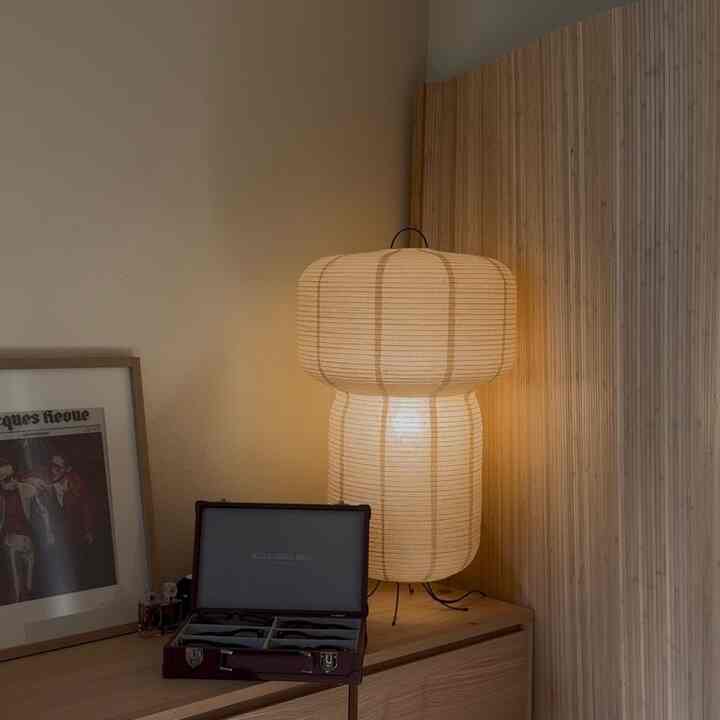 Beige and wood tone home office featuring bamboo room divider and rice paper floor lamp with cozy natural ambiance