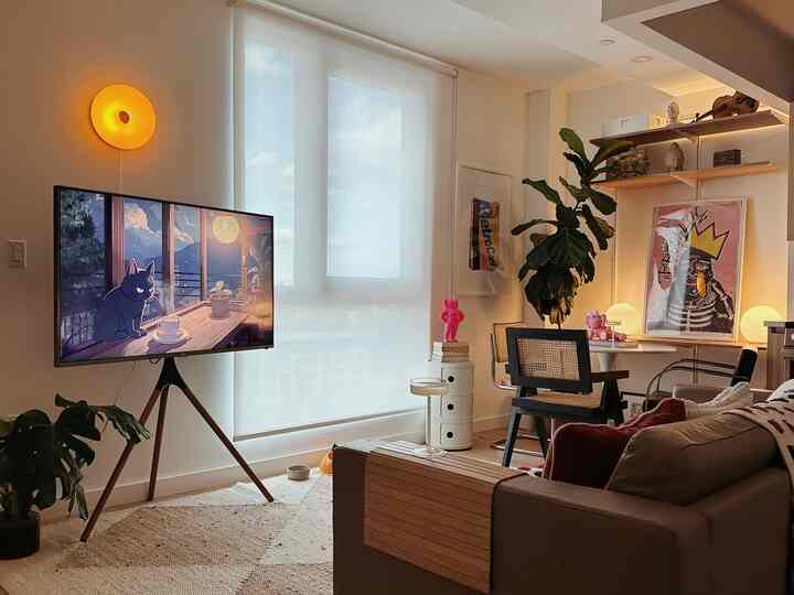 Cozy beige-toned mid-century modern living room featuring brown sofa and TV stand with warm ambient lighting