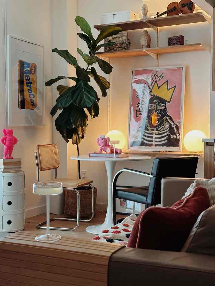 Mid-century modern dining room corner in white and wood tones featuring a white tulip table and assorted chairs with a cozy atmosphere